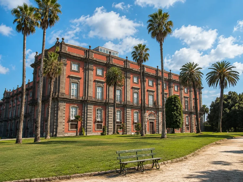 Capodimonte Museum in Naples surrounded by palm trees and gardens under a sunny sky with soft clouds.