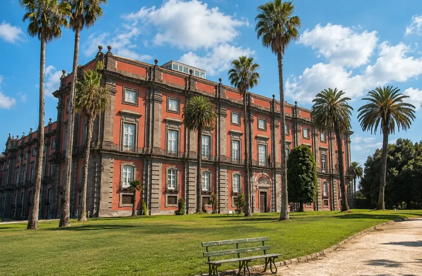 Capodimonte Museum in Naples surrounded by palm trees and gardens under a sunny sky with soft clouds.