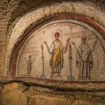 Ancient Christian fresco inside the Catacombs of San Gennaro in Naples featuring early religious artwork and underground stone architecture.