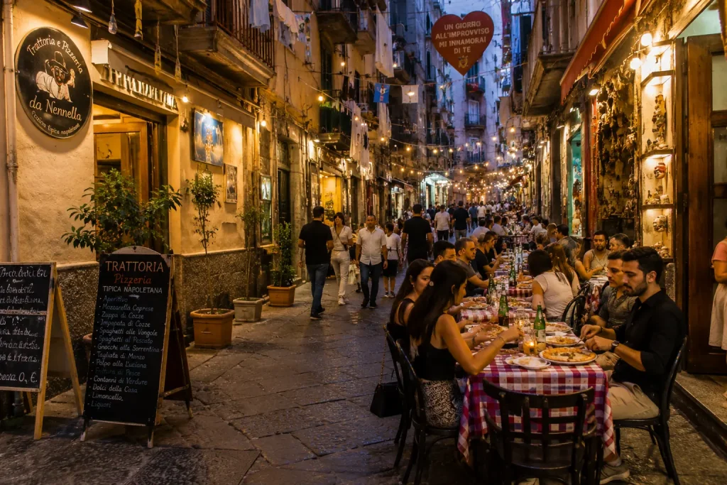 Outdoor dining in Quartieri Spagnoli Naples with traditional restaurants, street tables, and people eating in a narrow alley