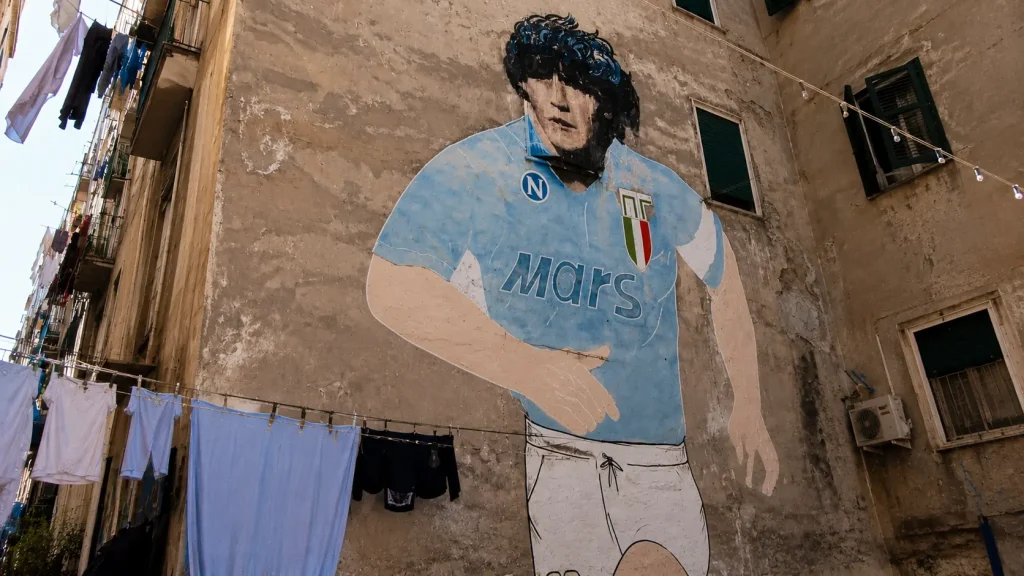 Diego Maradona mural in Quartieri Spagnoli Naples with hanging laundry and old Neapolitan buildings