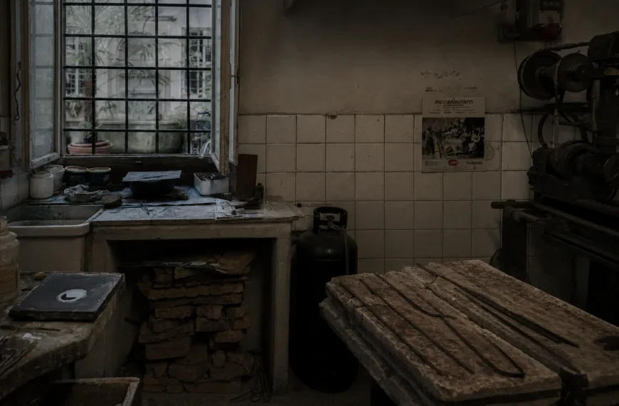 Traditional artisan workshop in Oltrarno Florence with vintage tools, worn wooden worktables, and moody overcast lighting