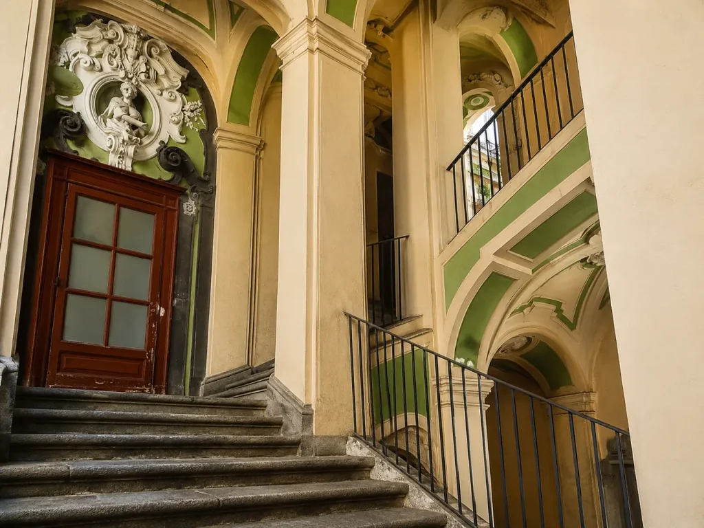 Detailed interior staircase and Baroque arches inside Palazzo dello Spagnolo in Naples, Italy