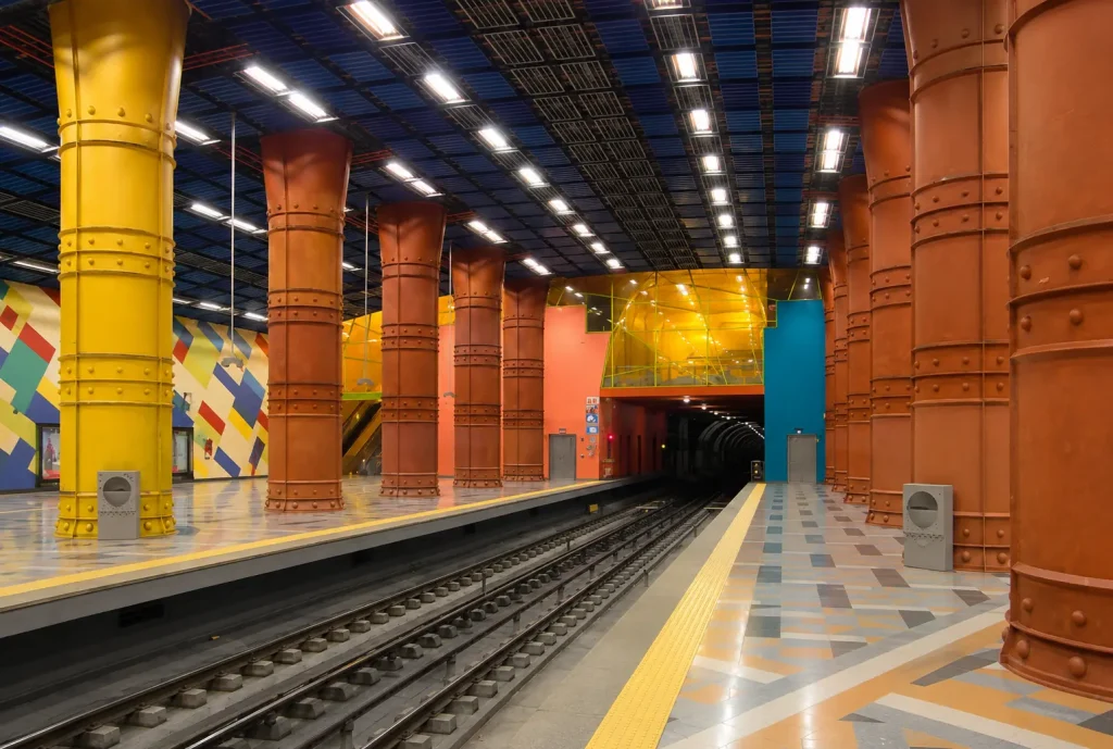 Platform level of Toledo Metro Station in Naples featuring colorful industrial columns, modern architecture, and the award-winning Art Stations design.